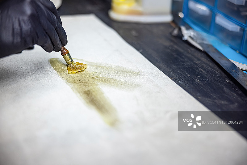在工艺维修店的皮革上涂胶图片素材