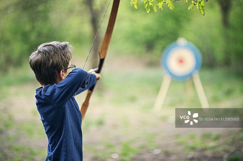 青少年男孩在森林中射箭图片素材