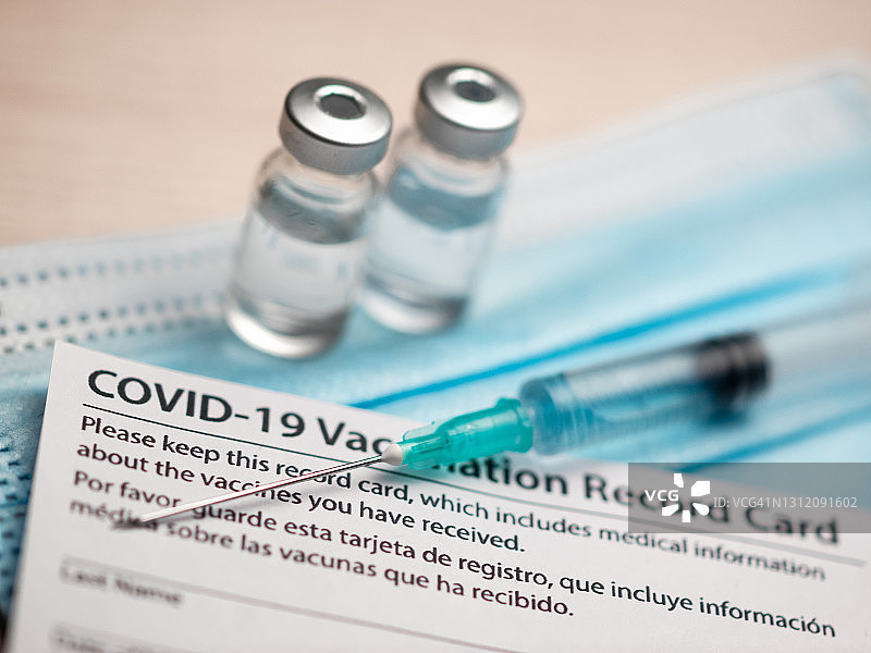新冠疫苗接种记录卡、护照、药瓶、注射器和医用口罩：免疫护照或旅行证明概念图片素材