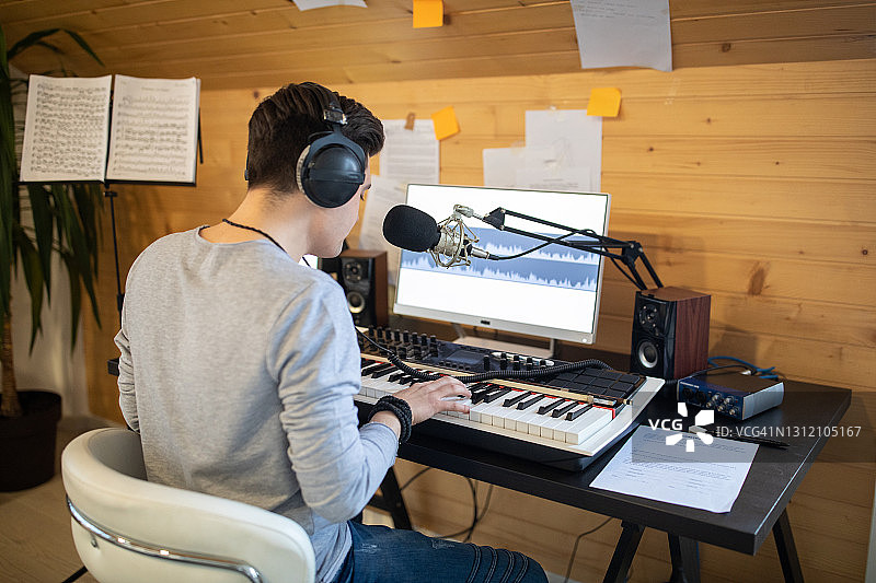 年轻音乐家在家里的音乐工作室里弹电子琴图片素材