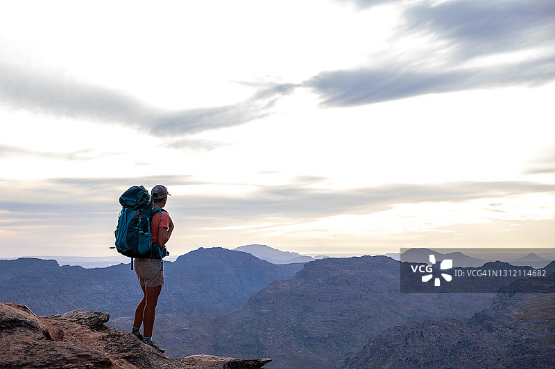 女性登山者在山顶欣赏日落美景图片素材