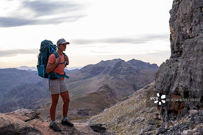 女性登山者在山顶欣赏日落美景图片素材