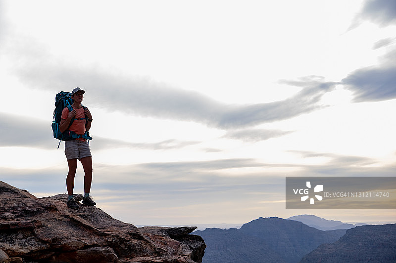 女性登山者在山顶欣赏日落美景图片素材