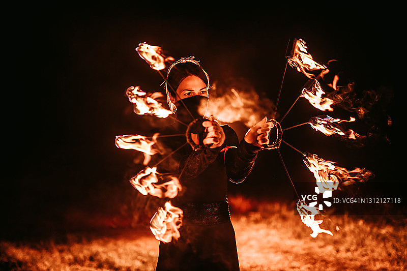 女人在夜晚进行火焰表演图片素材