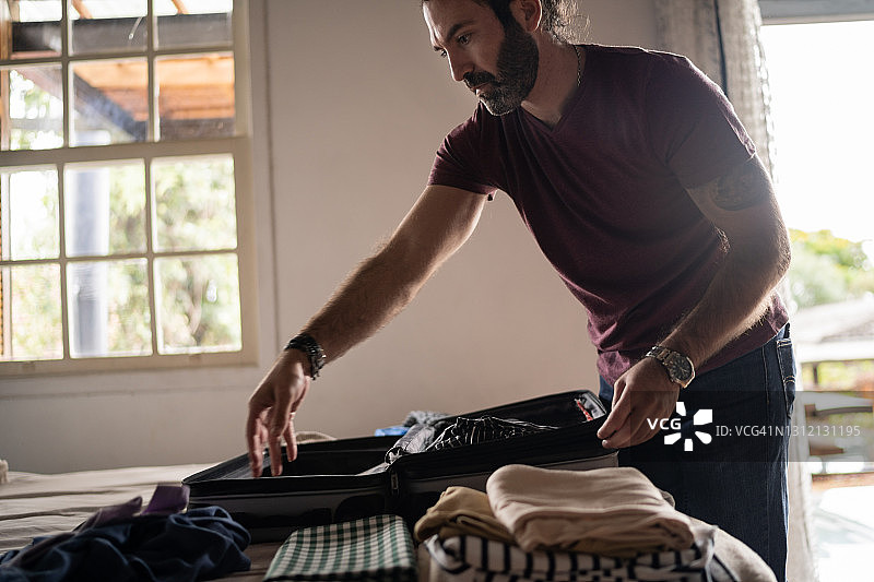 男人在家打包旅行背包图片素材