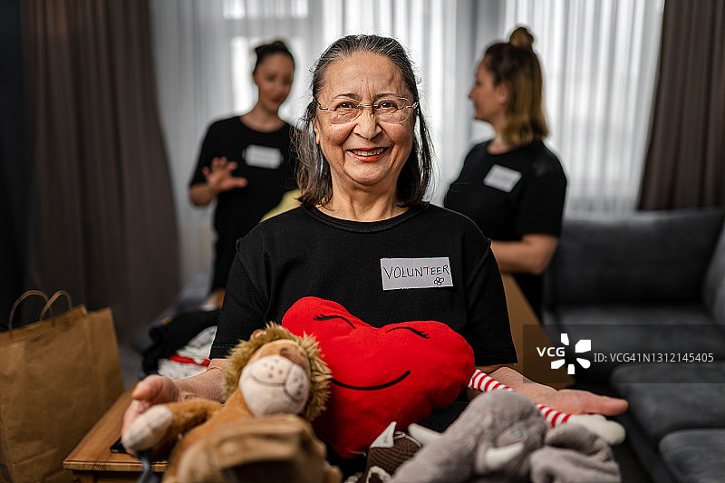 老年妇女拿着慈善捐赠箱图片素材