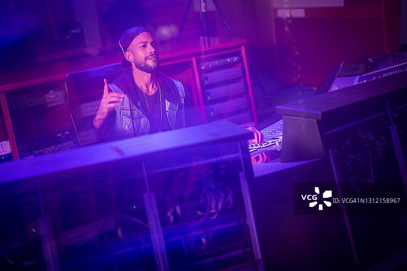 男子音响工程师在录音棚的大型调音台上享受工作图片素材