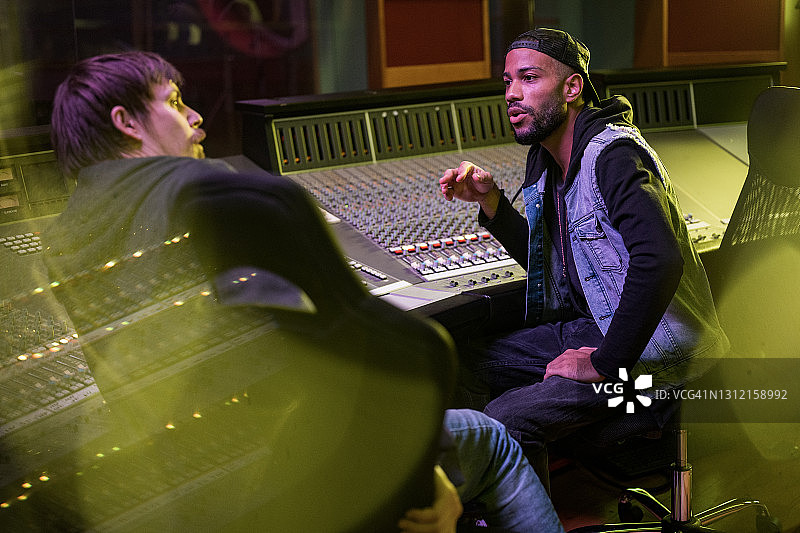 非裔美国音乐家在录音棚与录音师交谈图片素材