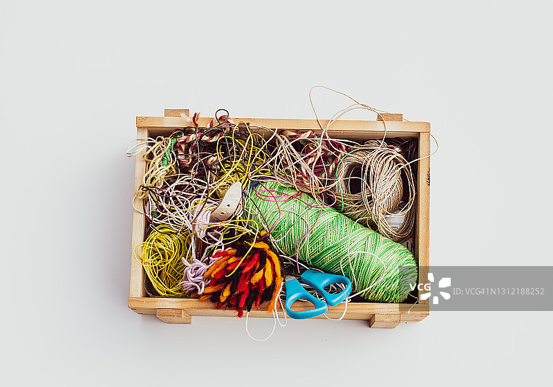 白色背景上装有不同凌乱缝纫线的木箱，工艺品图片素材