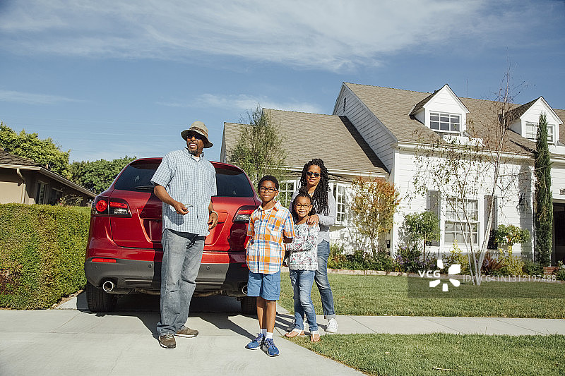 微笑的一家在晴天站在汽车旁图片素材