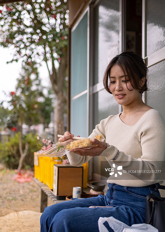 年轻女人在户外吃竹笋蒸饭图片素材