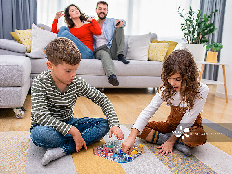 孩子们快乐地玩着棋盘游戏。图片素材