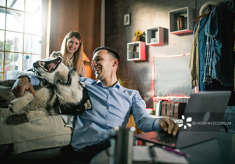 一对年轻夫妇在家与狗共度时光图片素材