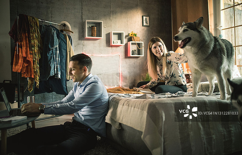 一对年轻夫妇在家与狗共度时光图片素材