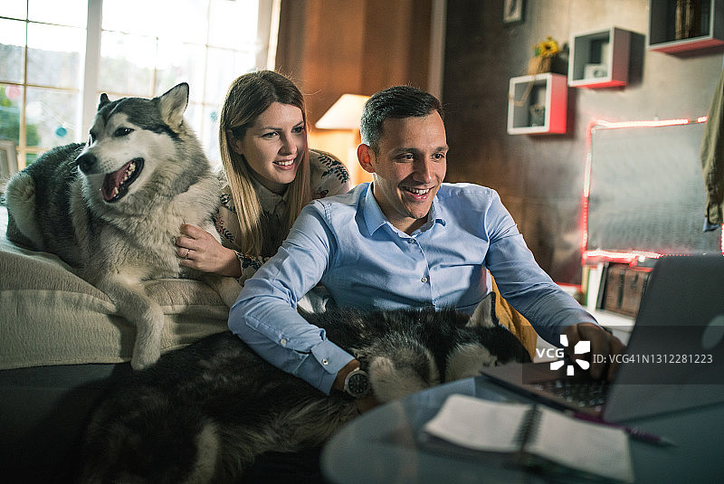 一对年轻夫妇在家与狗共度时光图片素材