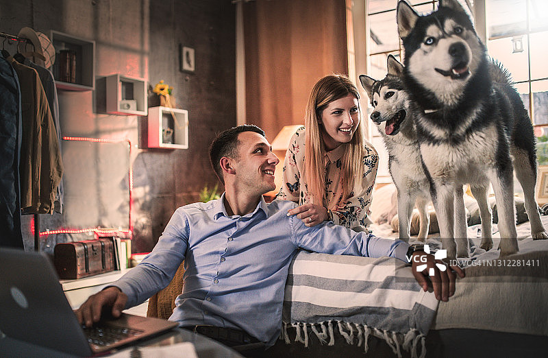 一对年轻夫妇在家与狗共度时光图片素材
