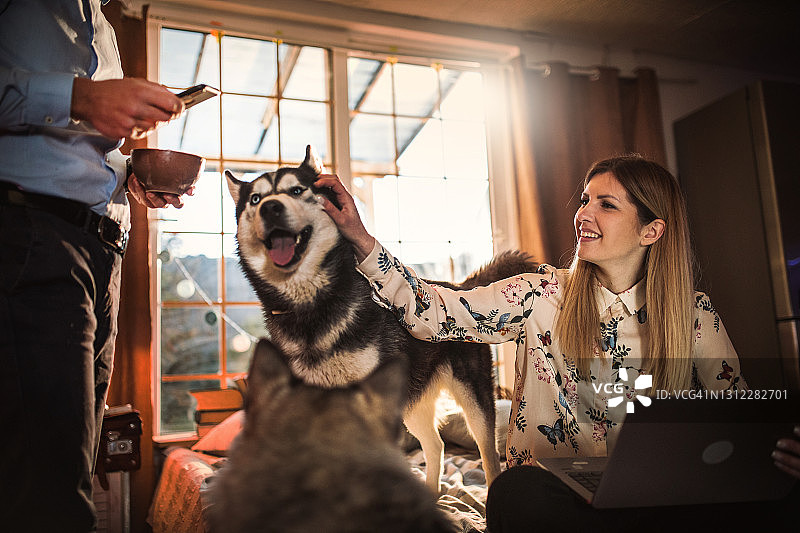 一对年轻夫妇在家与狗共度时光图片素材