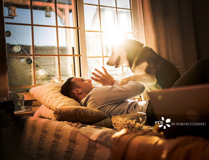 一对年轻夫妇在家与狗共度时光图片素材