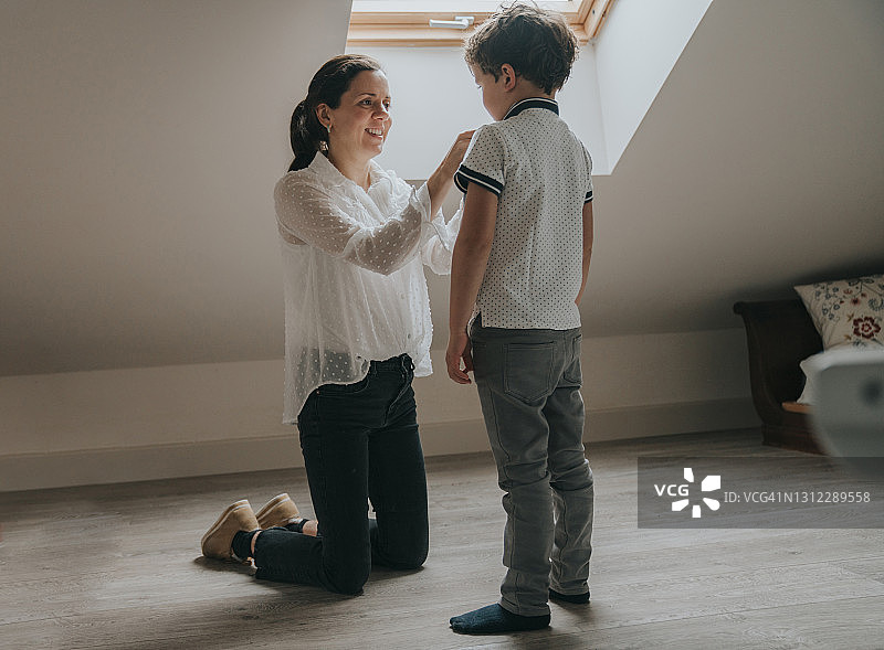 母亲帮儿子穿衣服图片素材