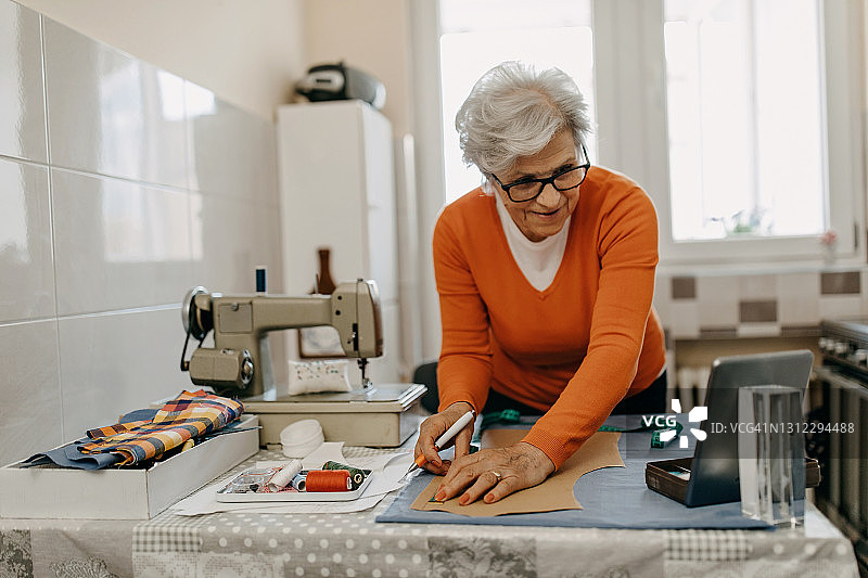 年长的女人从零开始缝制衬衫图片素材