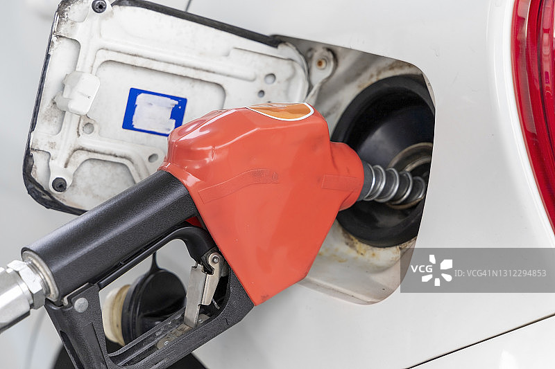 环境概念：加油站的燃油分配器，手持燃油喷嘴为汽车加油图片素材