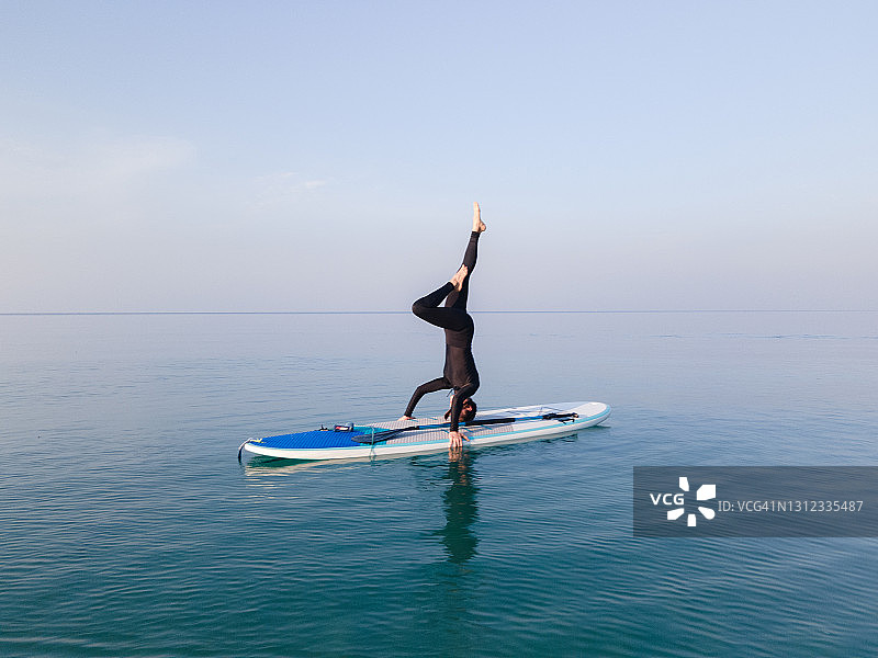 健康的女性一起在桨板上做瑜伽图片素材