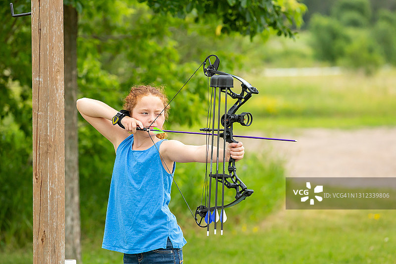 小女孩在户外射箭场拉弓射箭图片素材