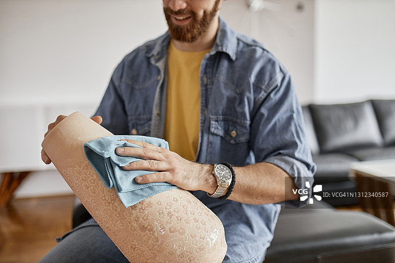 年轻男人用抹布清洁公寓房间特写：英俊的男人清洁家图片素材