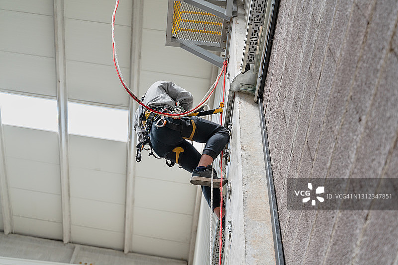 攀登到攀岩墙顶部的登山者图片素材