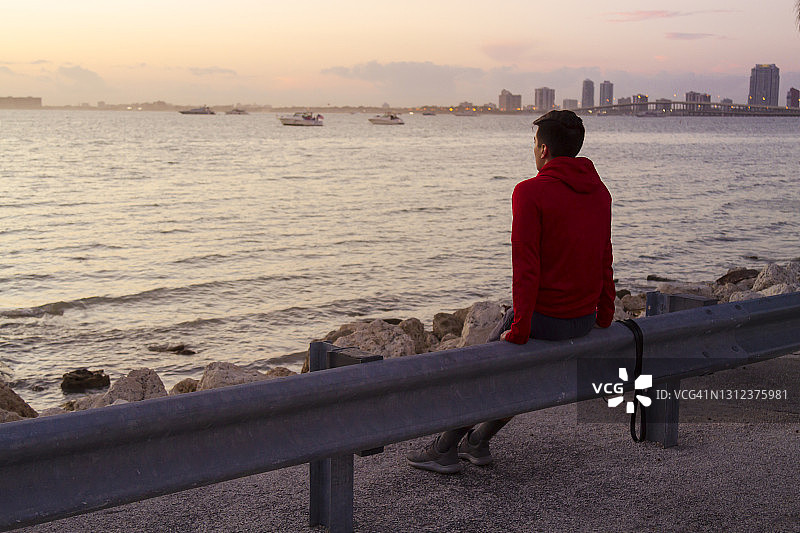 在佛罗里达州迈阿密海滩户外跑步后休息放松，为马拉松做练习和训练的年轻运动型男士图片素材