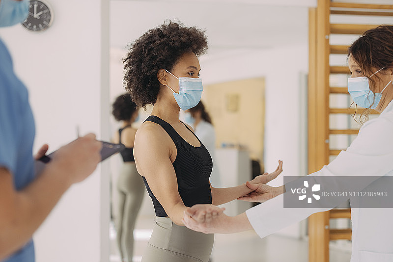 张开双臂站在女医生面前的美丽女人图片素材