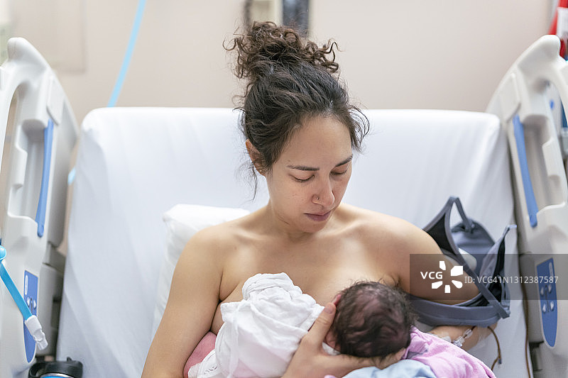 新手妈妈在医院病床上产后哺乳图片素材