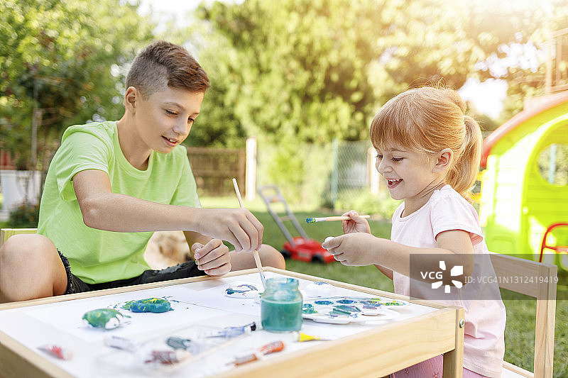 兄妹用水彩画画，开怀大笑图片素材