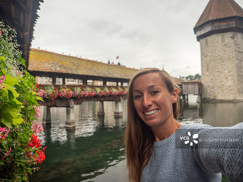 年轻女子与琉森市和著名桥梁自拍图片素材