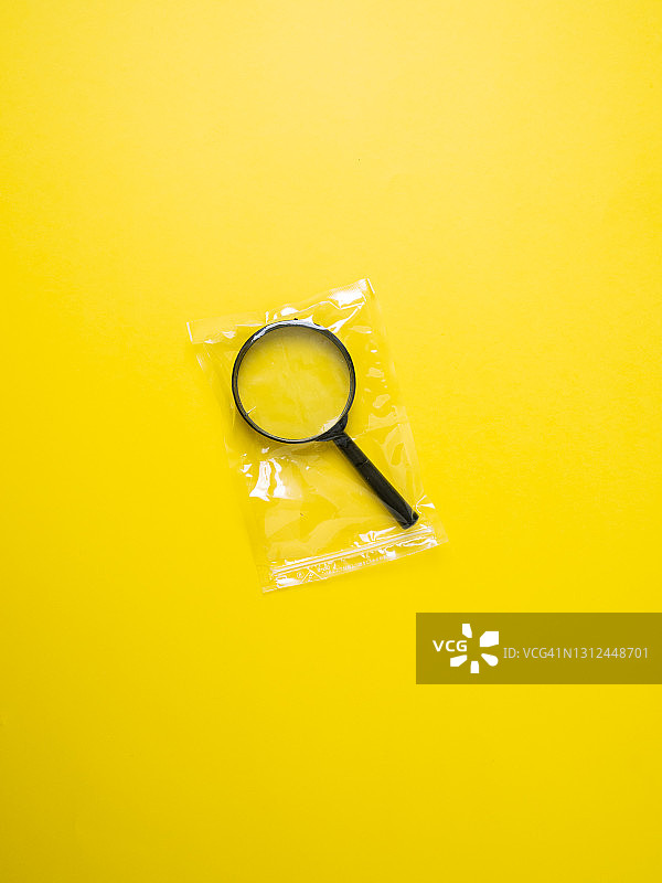 塑料袋包装的放大镜，犯罪证据概念图片素材