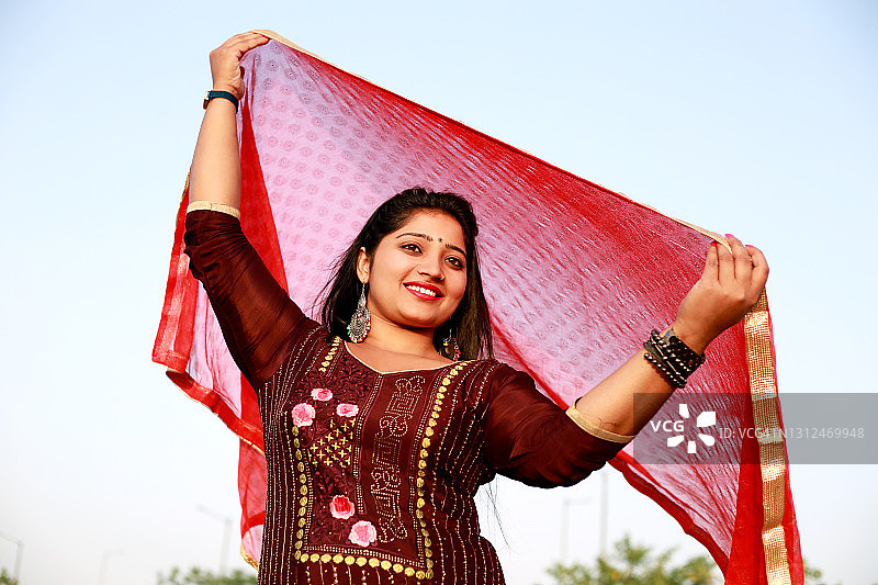 在户外飞舞围巾的年轻印度女子图片素材