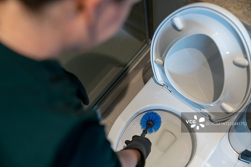 清洁工用刷子清洁浴室马桶图片素材