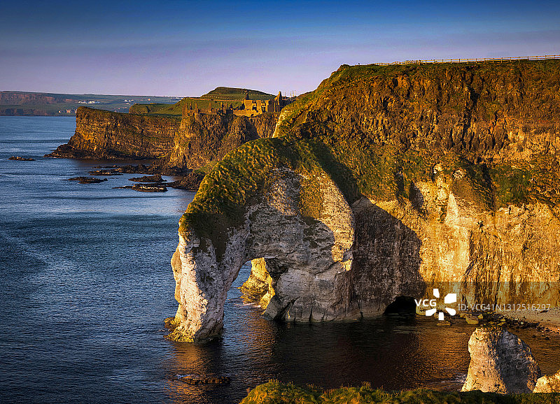 北爱尔兰安特里姆郡怀特罗克斯邓路斯城堡和大拱门日落图片素材