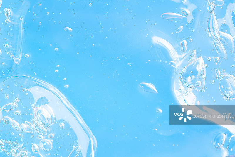 浅蓝色单色背景上有机透明凝胶的纹理，带有许多气泡。皮肤保湿或疫情期间预防新冠概念。近距离平铺风格图片素材