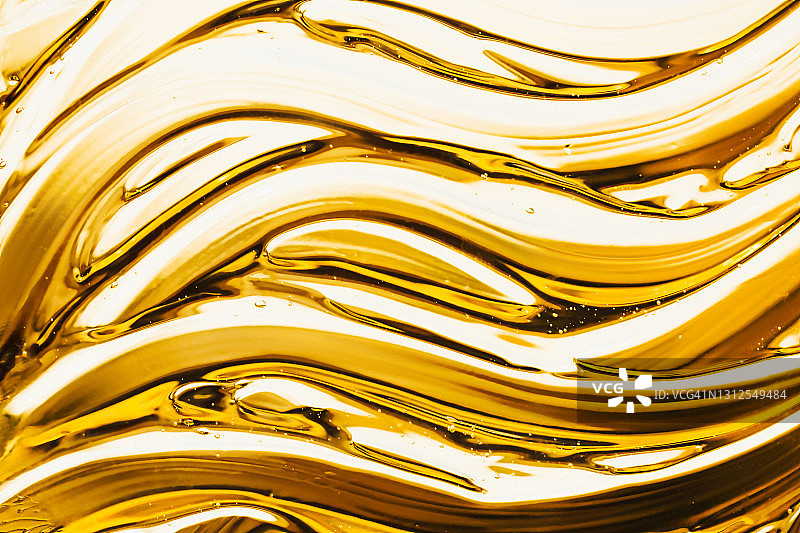 黄色背景上的透明凝胶涂抹抽象图案图片素材