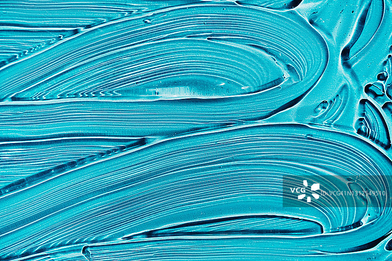 明亮蓝色背景上的透明凝胶涂抹纹理图片素材