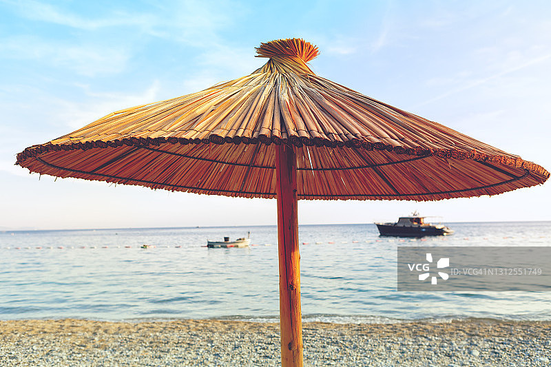 异国海岸的沙滩伞和背景中的船只图片素材