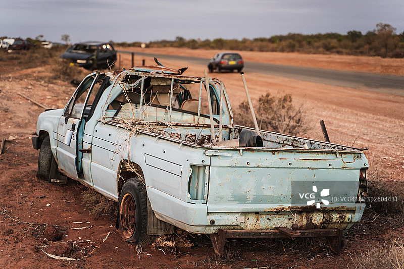废弃的蓝色皮卡车，沙漠废车场中的残骸车辆图片素材