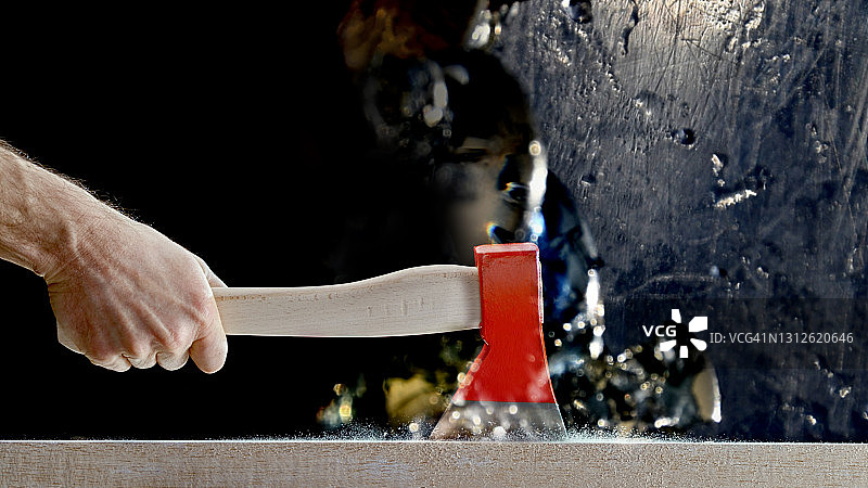 男子用短柄斧砍木头图片素材