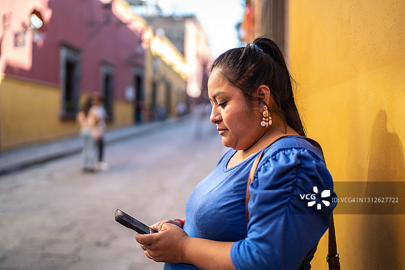 在街上使用智能手机的年轻女人图片素材