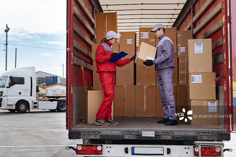 女人检查所有包裹是否已准备好交付，并在剪贴板上签字图片素材