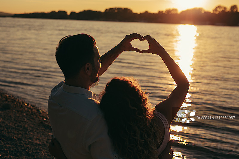 情侣在河边拿着心形装饰约会图片素材