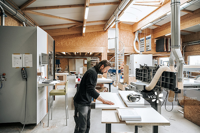 木匠师傅检查家具面板质量图片素材