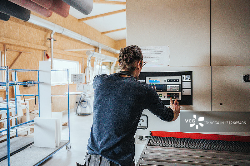 木匠在现代带式研磨机上调整设置图片素材