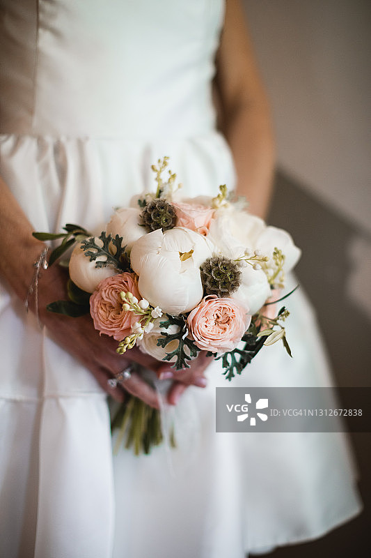 新娘手捧新郎牡丹花束的特写图片素材